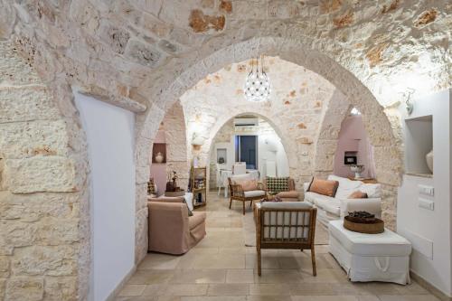 a living room with a stone wall at Trulli Garden Harmony by Rentbeat in Martina Franca