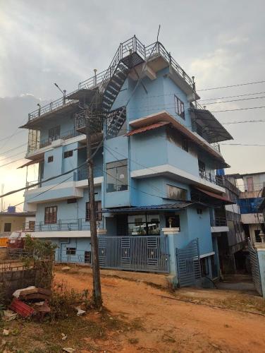 a blue building with a spiral staircase on it at BENCH HOTEL VAGAMON in Vagamon