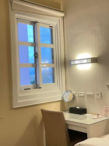a room with a desk and a window at Joy Hotel in Taitung City