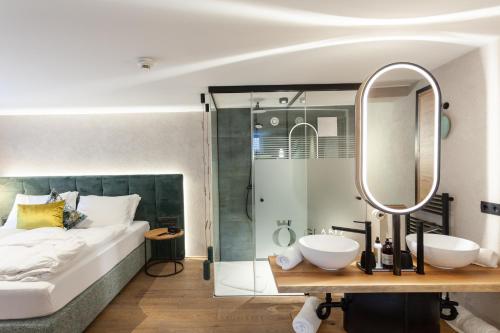 a bedroom with a bed and two sinks and a mirror at Glanz & Glory Sölden in Sölden