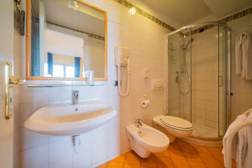 een badkamer met een wastafel, een toilet en een douche bij Mendolia Beach Hotel in Taormina