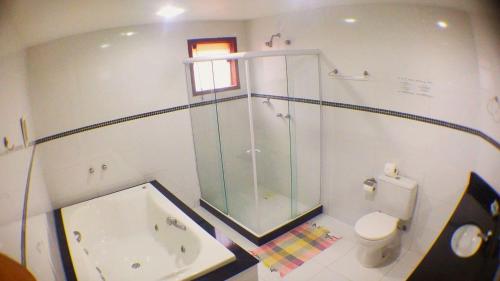 a bathroom with a shower and a toilet and a tub at BemTeVi Em Búzios in Búzios