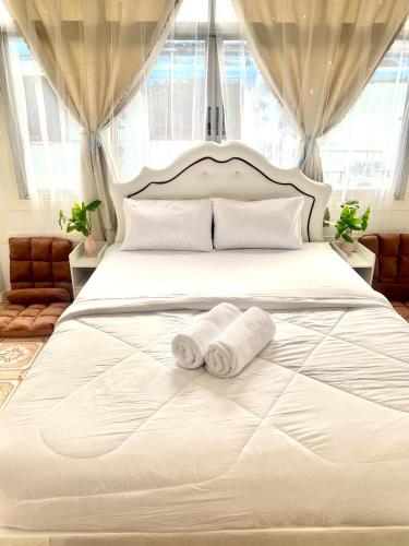 1 dormitorio con 1 cama blanca y 2 toallas en Guesthouse Station en Bangkok