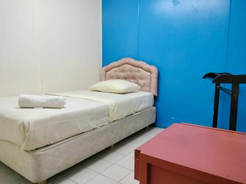 a bedroom with a bed and a blue wall at Grand Heritage Hotel in Melaka