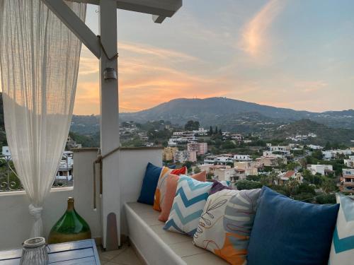 a couch on a balcony with a view of a city at TaliaKà B & B in Lipari