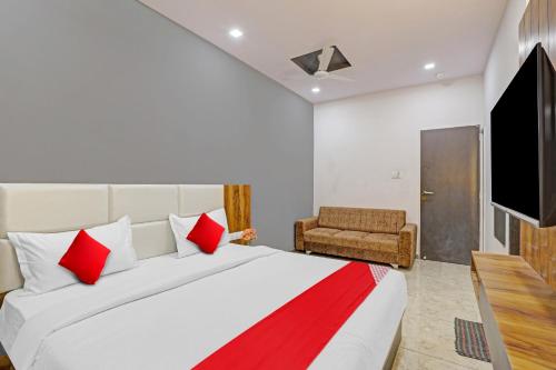 sypialnia z dużym łóżkiem i telewizorem w obiekcie Collection O Hotel Dumas Rooms & Restaurant w mieście Surat