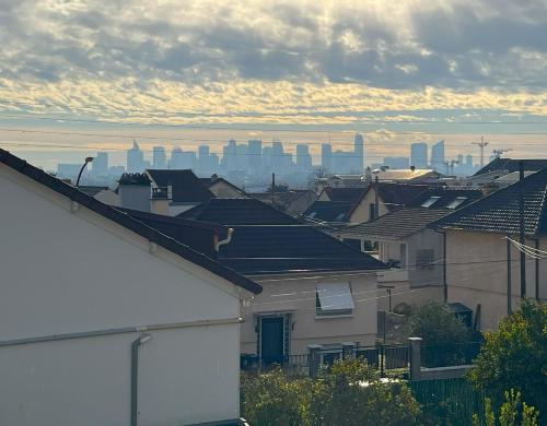 a view of a city with roofs of houses at Kyriad Argenteuil in Argenteuil
