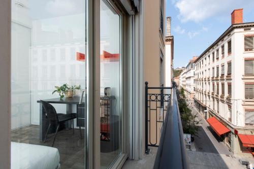 un balcon avec une table et une vue sur une ville dans l'établissement Résilodge Lyon 2, à Lyon