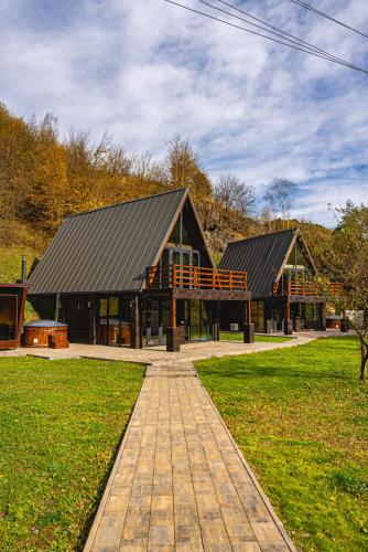 a large building with a black roof in a park at Valea Mosului - Cozy A Frame in Petroşani