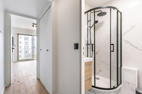 une salle de bain avec une douche avec une porte vitrée dans l'établissement Magnifique Studio neuf, à Paris