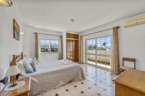 um quarto com uma cama e uma grande janela em Villa Casa Lourenco by Villa Plus em Albufeira