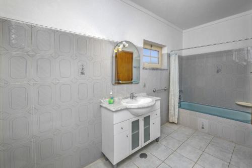 uma casa de banho branca com um lavatório e um chuveiro em Villa Casa Lourenco by Villa Plus em Albufeira
