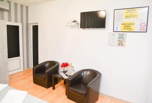 a waiting room with two leather chairs and a table at Casa Millelune in Focşani