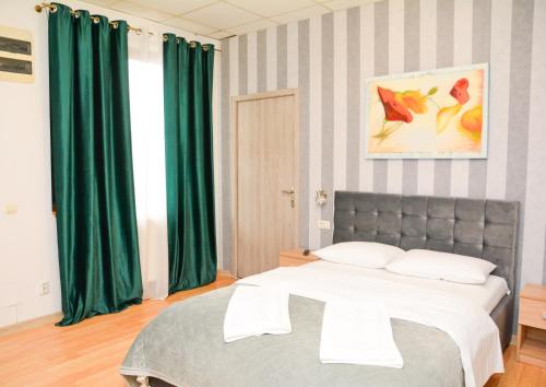 a bedroom with a large bed with green curtains at Casa Millelune in Focşani