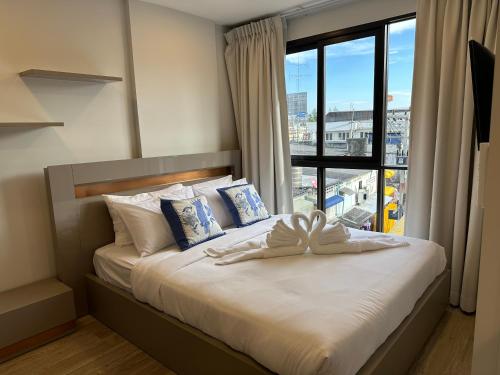 a bedroom with a bed with a large window at New Cosy Apartment at Marvest Huahin City Center in Hua Hin