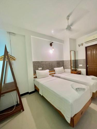 a hotel room with two beds and a window at Leisure Boutique Maafushi 维尼家 in Maafushi