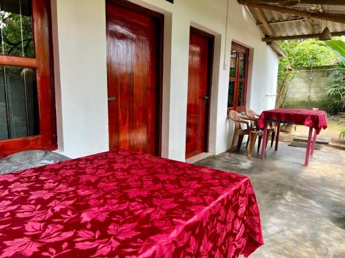 een slaapkamer met een bed met een rode omslag bij Sun Beach in Tangalle