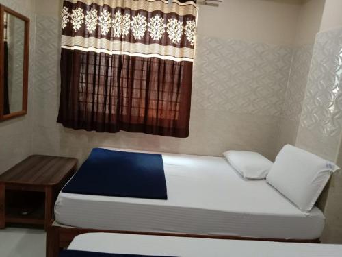 a small bedroom with a bed and a window at Vishnu Bhavan in Tirupati