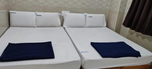 two beds in a room with blue pillows on them at Vishnu Bhavan in Tirupati
