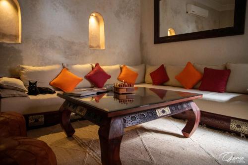 uma sala de estar com um sofá e uma mesa com almofadas em Riad Zoraida em Marrakech