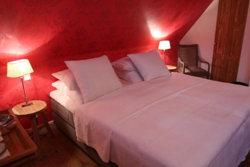 a bedroom with a large white bed with red walls at Hotel No. 11 in Lüdinghausen
