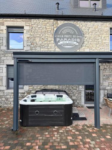 a hot tub in front of a building at La porte du paradis in La Roche Madoux