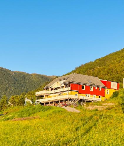 a large building on a hill in a field at Romsdal Feriesenter - Holiday and boat rental in Møre og Romsdal in Rekdal