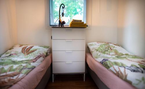 een kleine slaapkamer met 2 bedden en een raam bij Davis residence in Voorthuizen