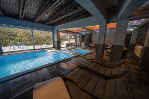 a large swimming pool with two chairs in a house at Popas Turistic Transfagarasan in Cârțișoara