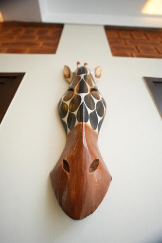 a wooden giraffe ornament hanging on a wall at UNGA VEEDU PAY AND STAY in Tiruvannāmalai