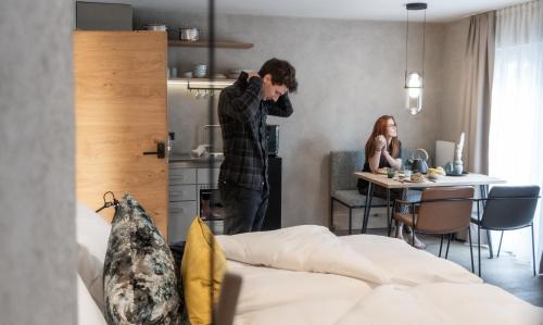 a man standing in front of a kitchen with a woman at Glanz & Glory Appartements Sölden in Sölden