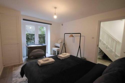 a bedroom with a black bed with two towels on it at Apartment - Heart of London! in London