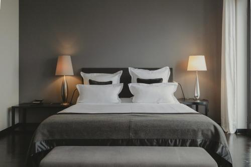 a bedroom with a large bed with pillows and two lamps at A-ROSA Hotel Ceres am Meer - Adults Only in Binz