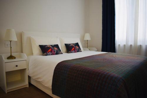 a bedroom with a bed with two pillows on it at Nuovissimo trilocale in centro : Ca’ Del Mar in Sanremo