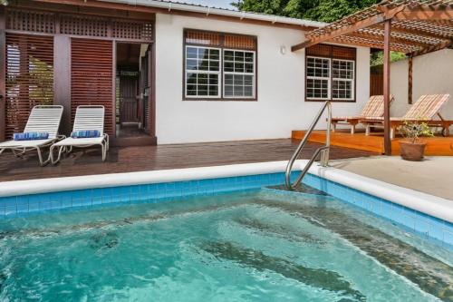 una piscina frente a una casa en Charming cottage located in Cap Estate - Orchid Cottage home, en Cap Estate