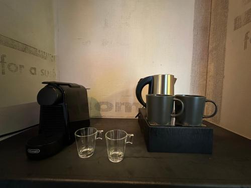 una cafetera y dos vasos en un mostrador en Paradox, en Tesalónica