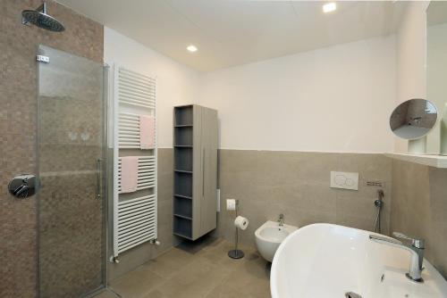 een badkamer met een bad, een douche en een wastafel bij Al segnavento Tramontana in Toscolano Maderno