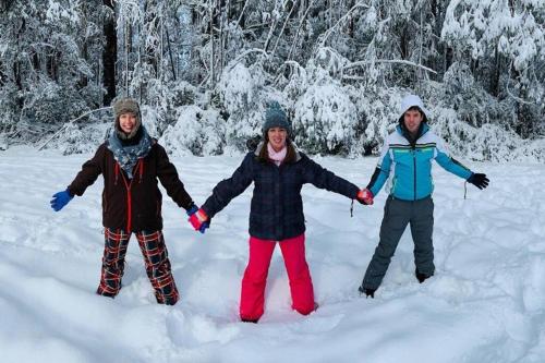 three people standing in the snow holding hands at Jilly Park Farmstay Experience Discover Authentic Farm Life Complimentary Breakfast Included in Buln Buln