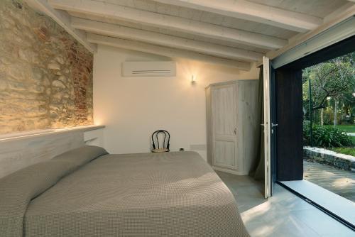 een slaapkamer met een bed en een glazen schuifdeur bij Al segnavento Tramontana in Toscolano Maderno