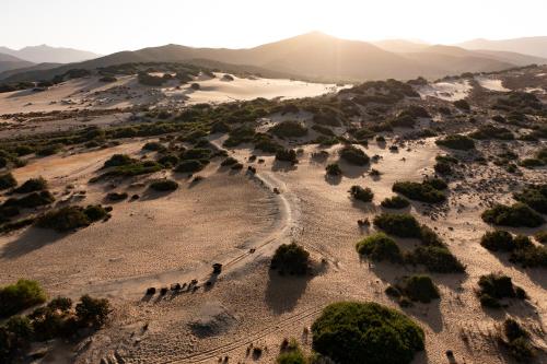 an aerial view of the desert with a group of people at Hotel Le Dune Piscinas in Ingurtosu