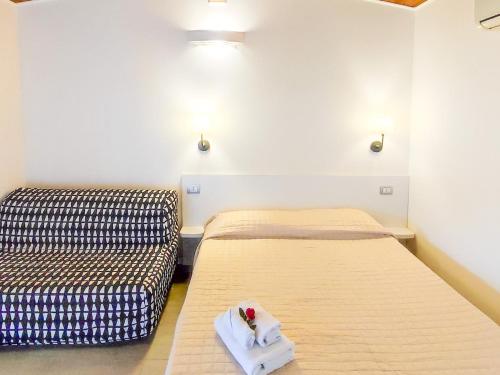 two beds in a room with a flower on a towel at Arco delle Rose Rooms in Agropoli