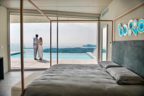 a bride and groom standing on the balcony of a house at Infinity Villa Salò in Salò