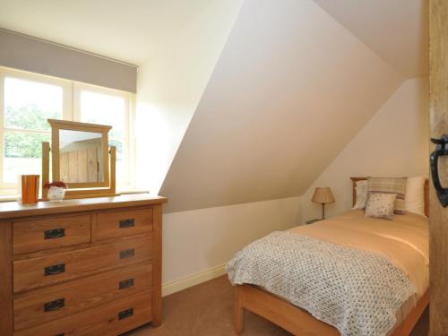 a bedroom with a bed and a dresser with a mirror at 2 Bed in Newthorpe 47031 
