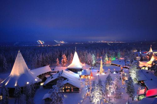 una ciudad cubierta de nieve por la noche con luces de Navidad en Rovaniemi Studio 32, en Muurola