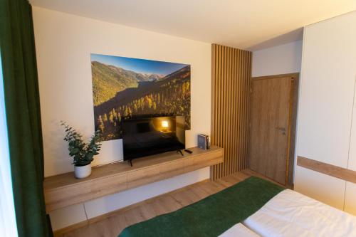 1 dormitorio con TV de pantalla plana en la pared en DAPELOVA Apartments - Tále, en Tale