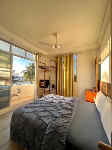 a bedroom with a bed and a view of the beach at Leisure Boutique Maafushi 维尼家 in Maafushi