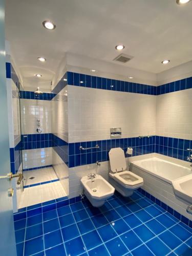 a blue and white bathroom with a tub and a toilet and a sink at La Porta Azzurra - Casa Vacanze in Como