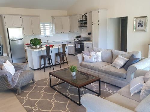 a living room with a couch and a table and a kitchen at The Lane Rodney Bay 1 bedroom rate - Newly renovated & tastefully furnished 3 bedroom house home in Rodney Bay Village