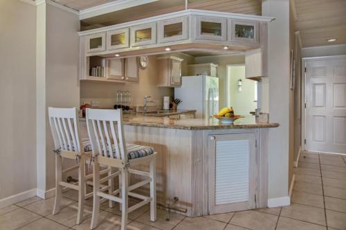 a kitchen with a island with two chairs and a counter at The Harbour #6 - 2 Bedrooms in Rodney Bay townhouse in Gros Islet