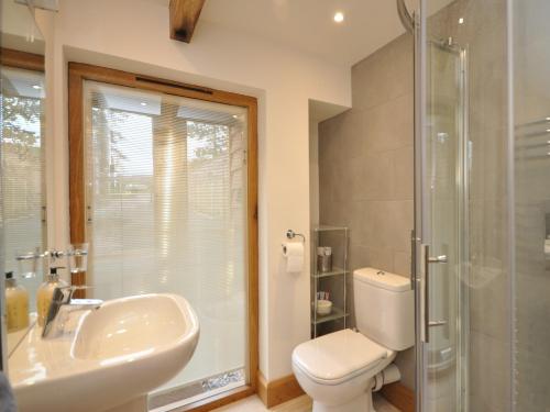 a bathroom with a toilet and a sink and a shower at 3 Bed in Leominster 50517 in Pencombe